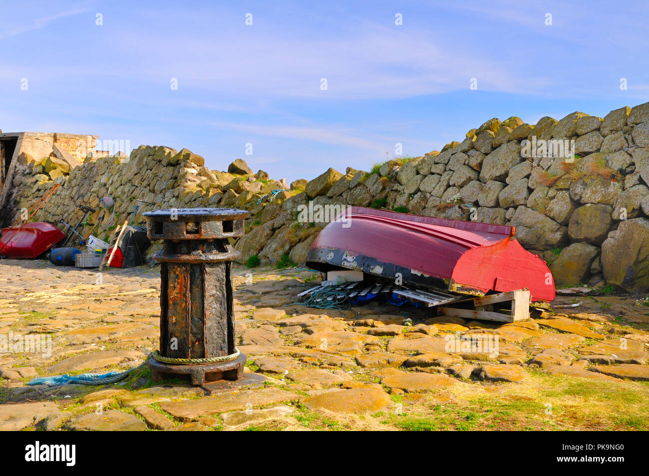 Upturned boat and old capstan at Pettycur Harbour, Kinghorn, Scotland Stock Photo