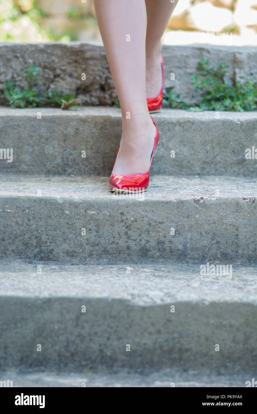 Woman in red shoes walking down the stairs Stock Photo
