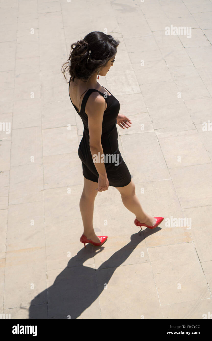 High angle view of a woman in black dress walking away outdoors Stock ...
