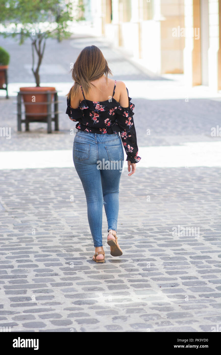 Rear view of a young woman walking away Stock Photo - Alamy
