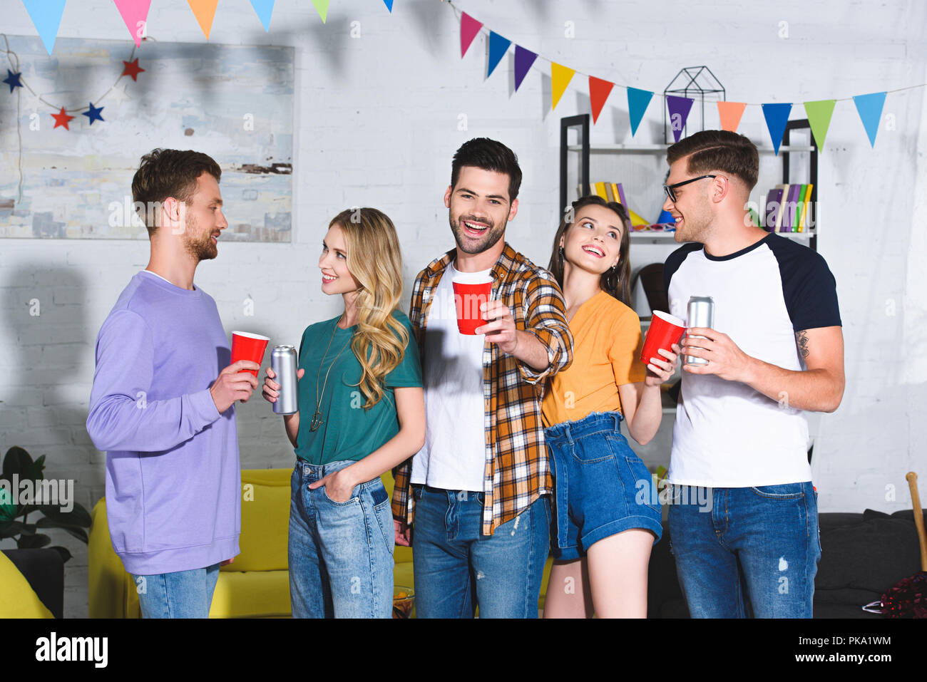 happy young friends drinking beer while having fun together at home ...