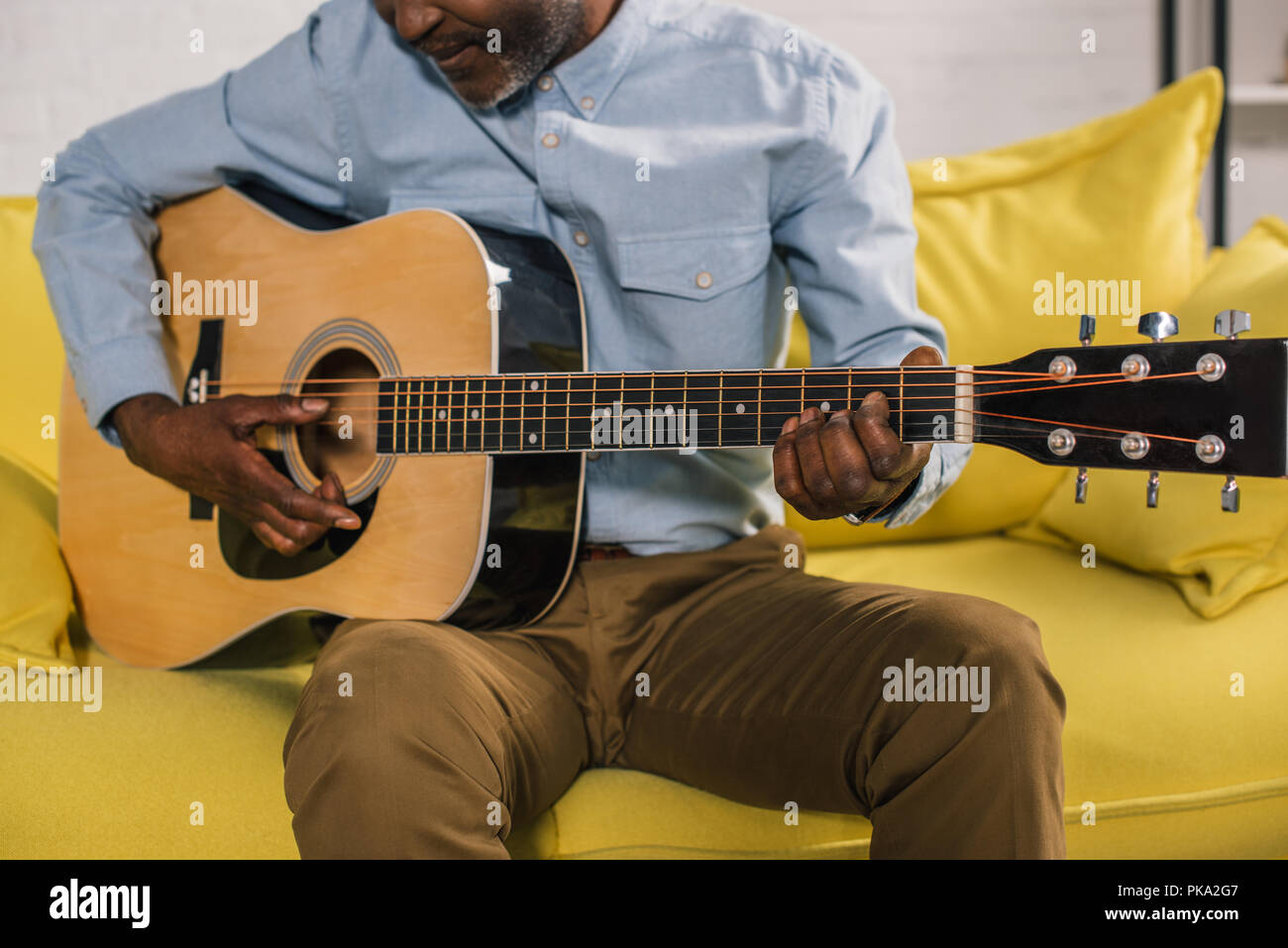 cropped shot of senior african american man playing acoustic guitar at ...