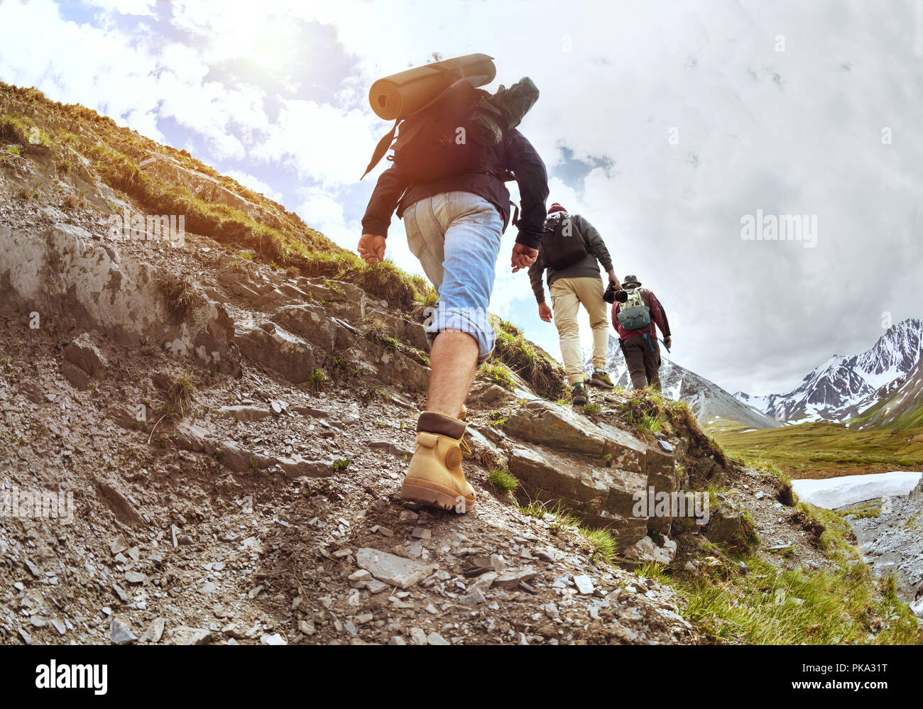 Group of tourists walking uphill by trek Stock Photo