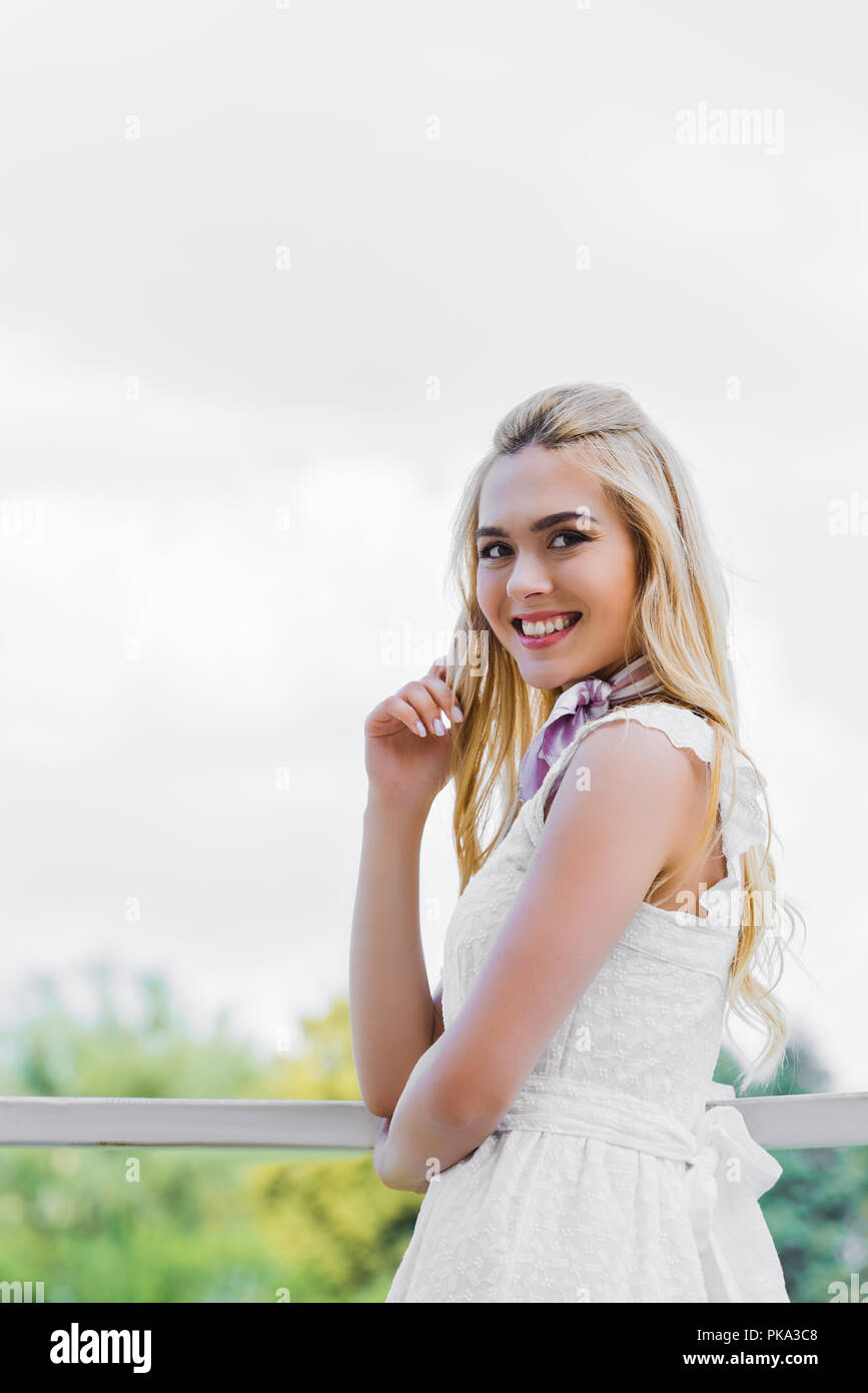 beautiful young blonde woman in white dress smiling at camera Stock ...
