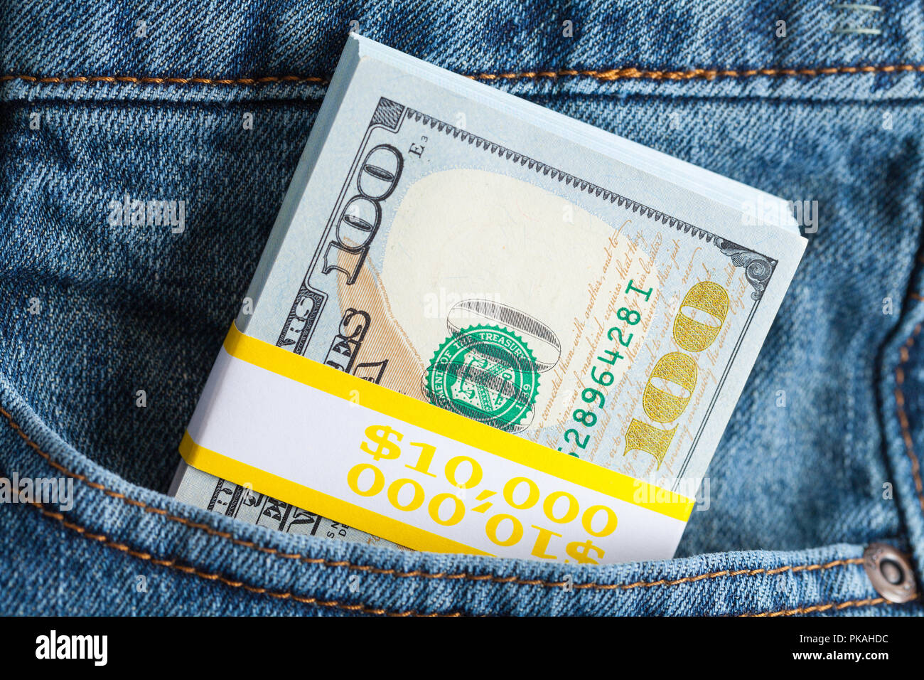 Stack of Cash Stuffed in Blue Jeans. Stock Photo