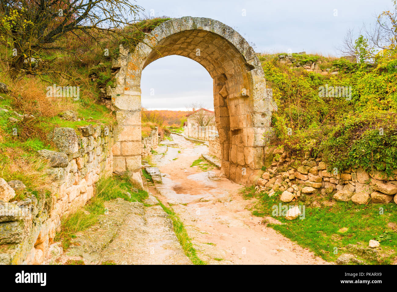 Ancient stone road and ruins of an arch in the cave town of Chufut-Kale ...