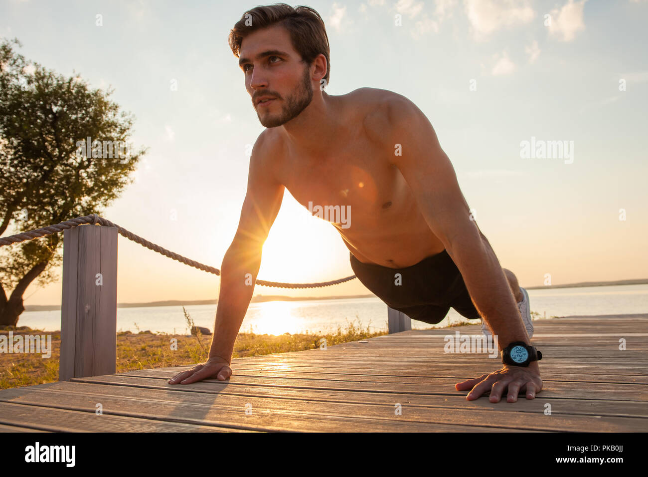 Picture of a young athletic man doing push ups outdoors Stock Photo