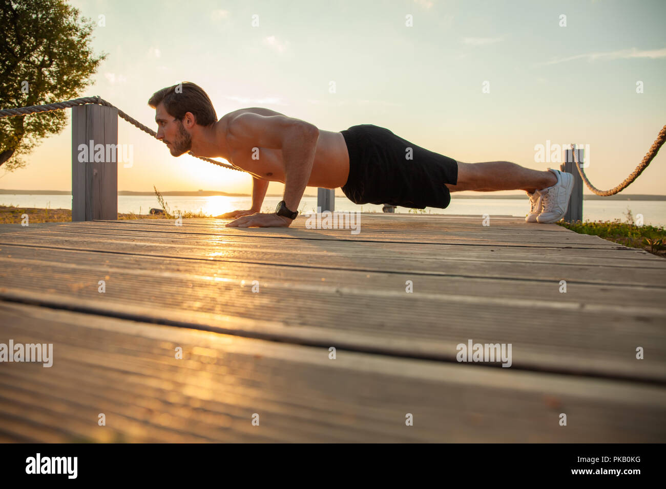 Picture of a young athletic man doing push ups outdoors Stock Photo - Alamy