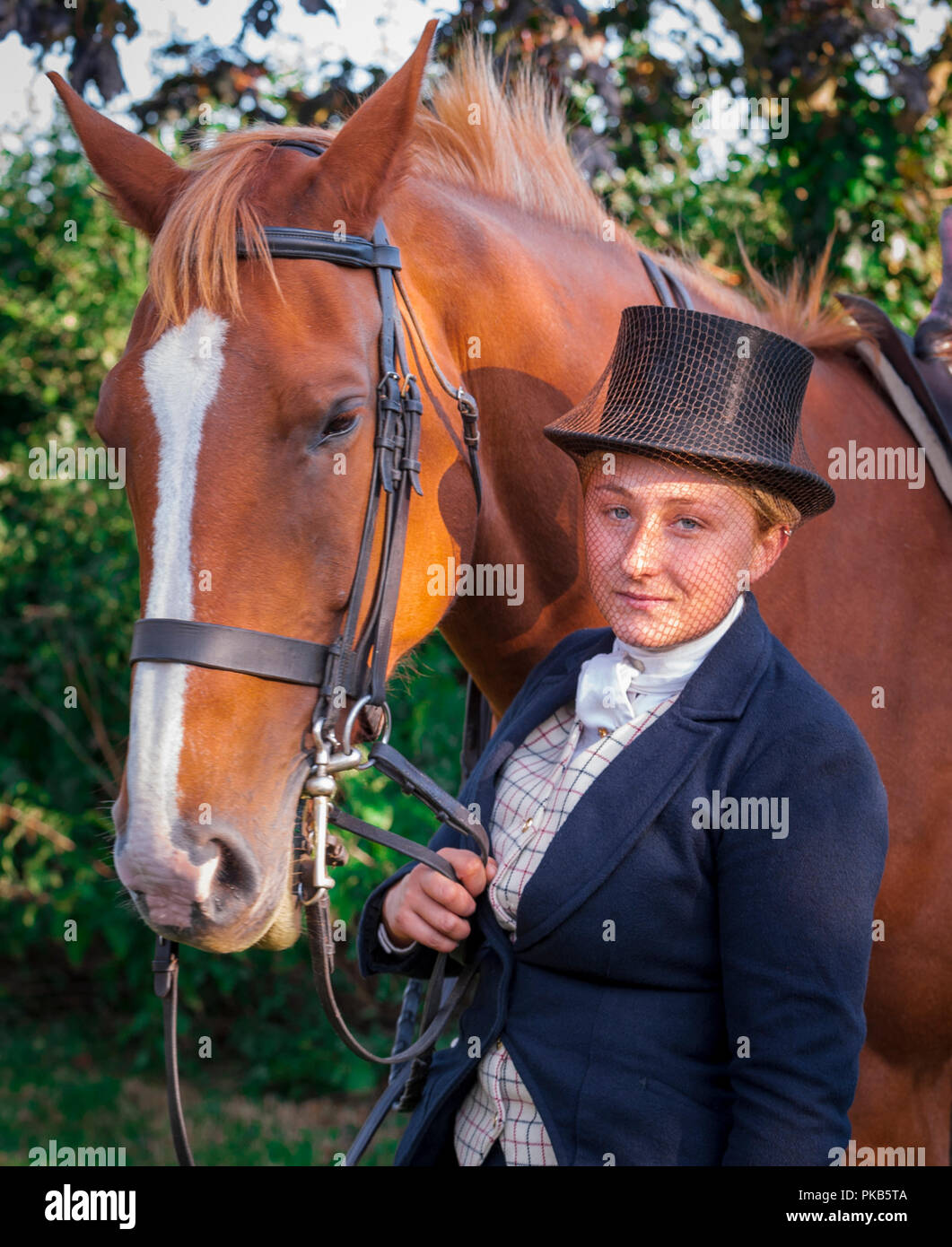 An elegent young woman stood with her horse dressed in traditional riding  top hat and face veil Stock Photo - Alamy