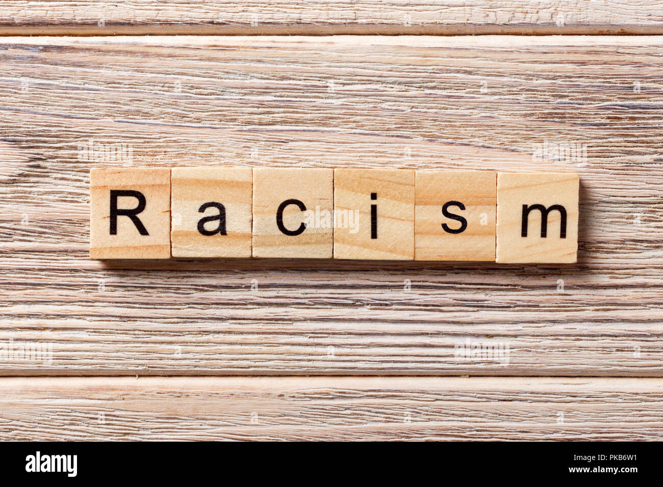 Racism word written on wood block. Racism text on table, concept. Stock Photo