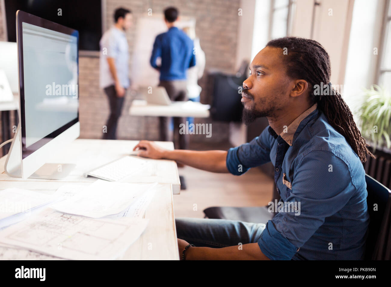 Young architect working on computer in office Stock Photo