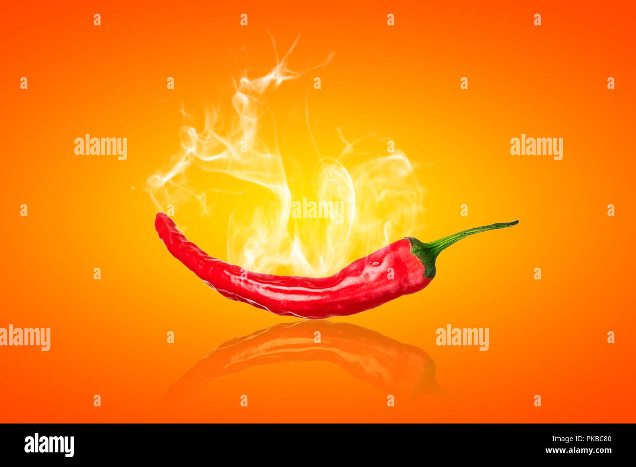 single red chili peppers  with white smoke on orange background Stock Photo