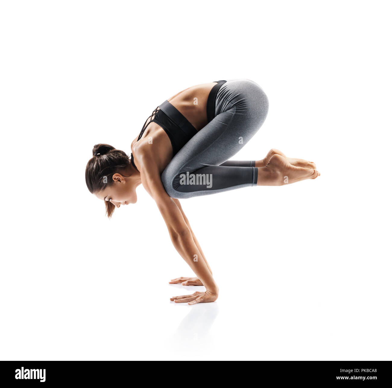 Sporty young woman doing yoga practice isolated on white background ...