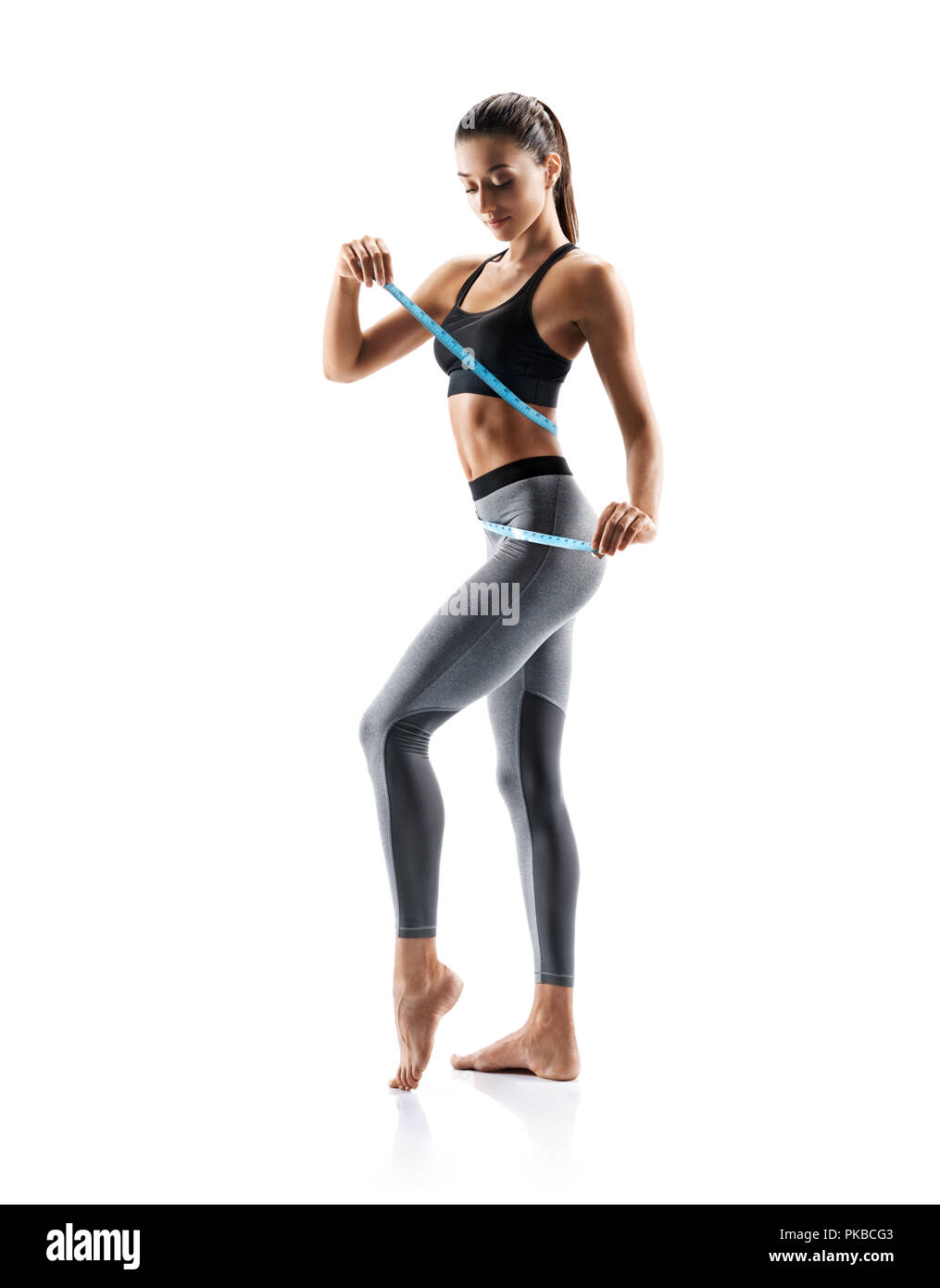 Young slim girl in sportswear isolated on white background. Concept of healthy life and natural balance between body and mental development. Full leng Stock Photo