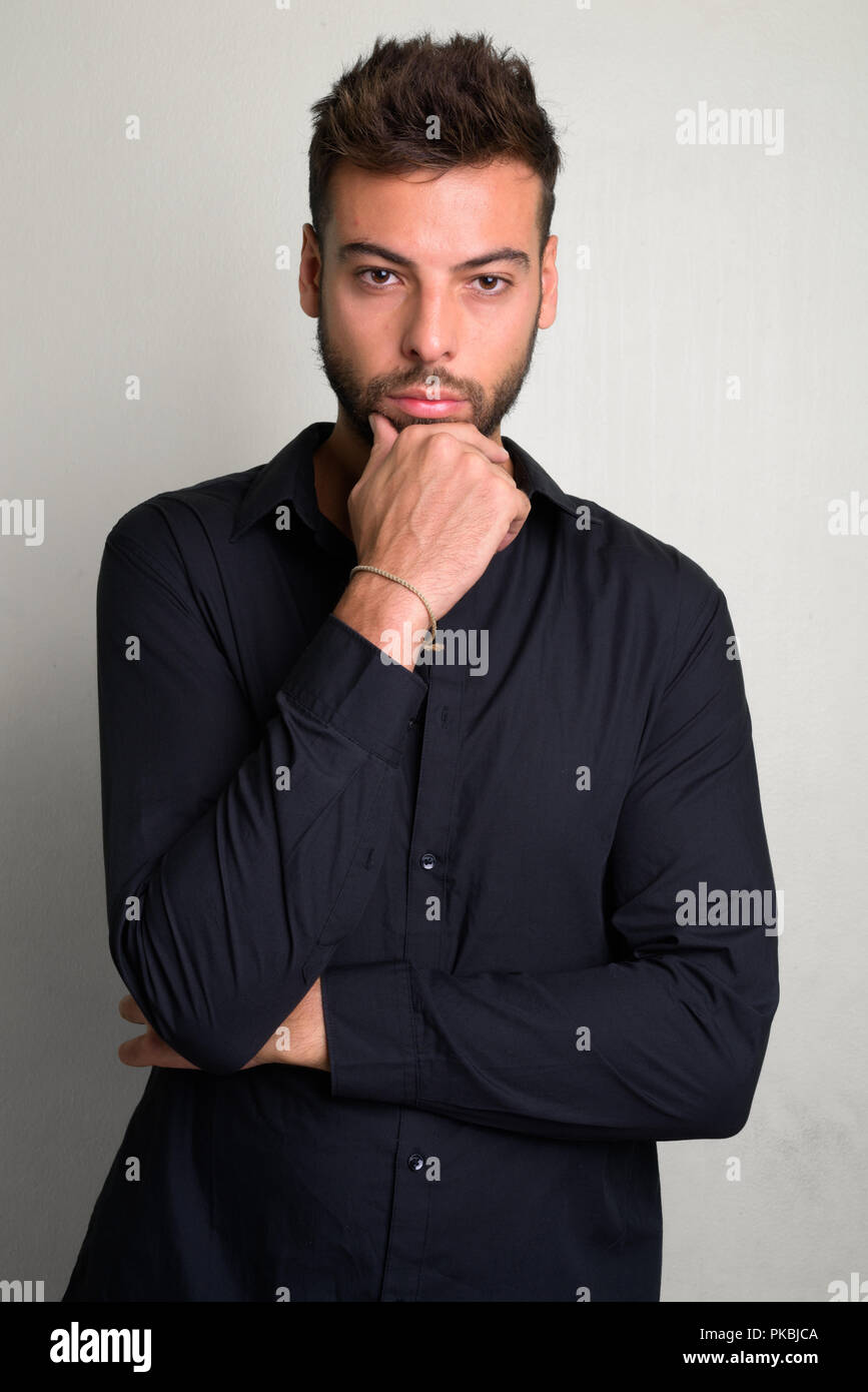 Studio shot of young handsome bearded businessman Stock Photo