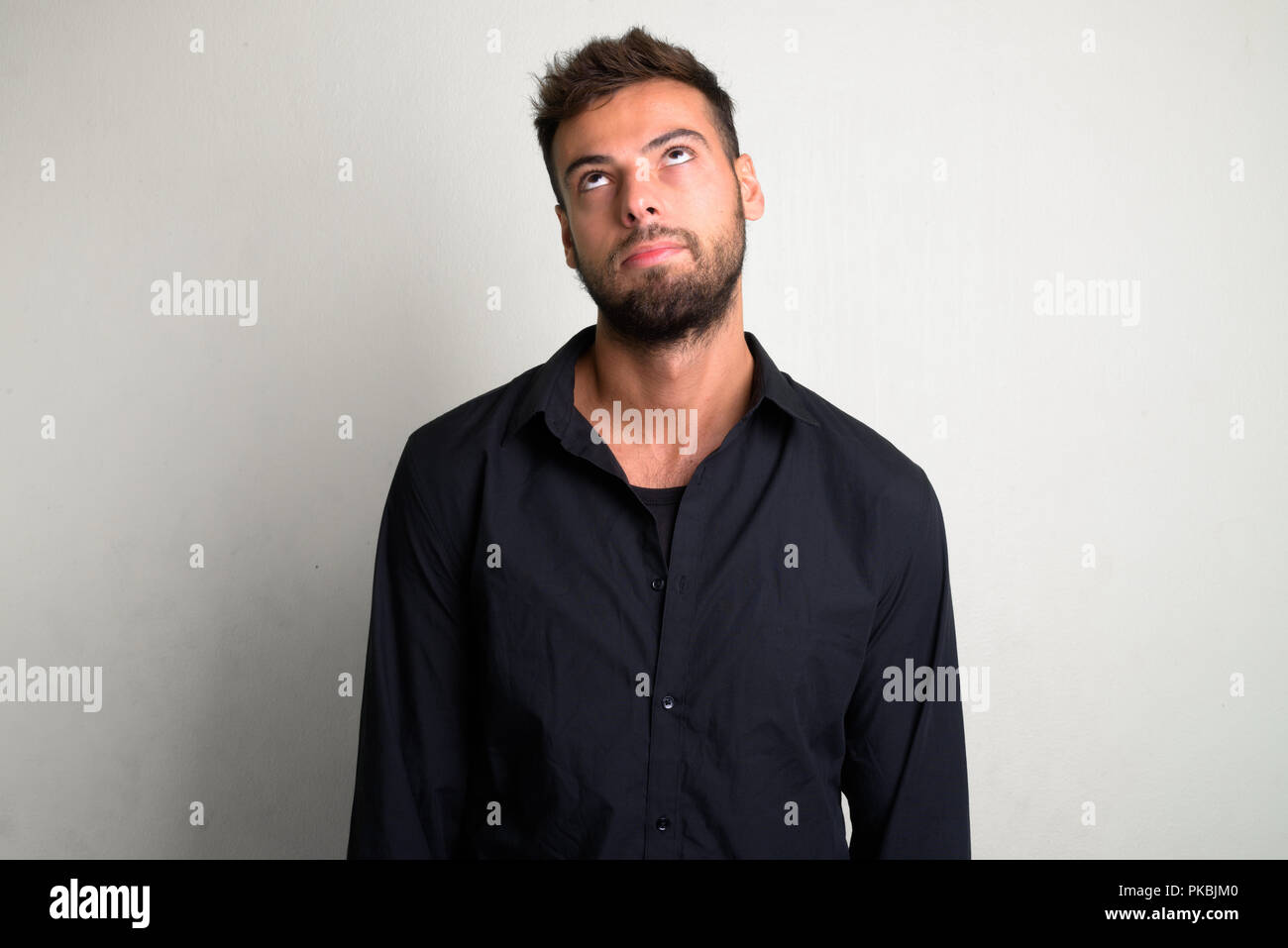 Studio shot of young handsome bearded businessman Stock Photo