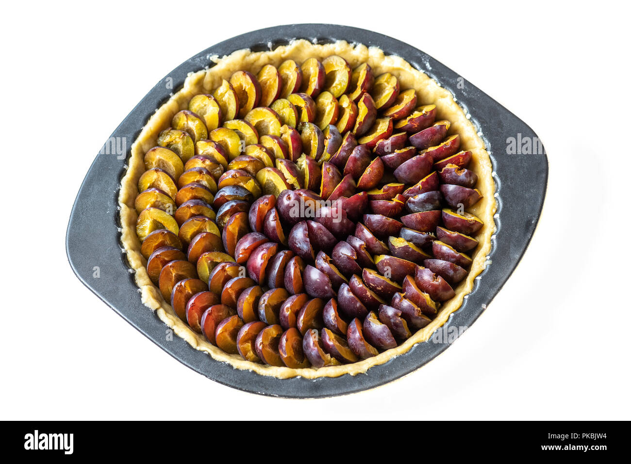 Pie with Alsace quetsches before cooking on white background Stock Photo