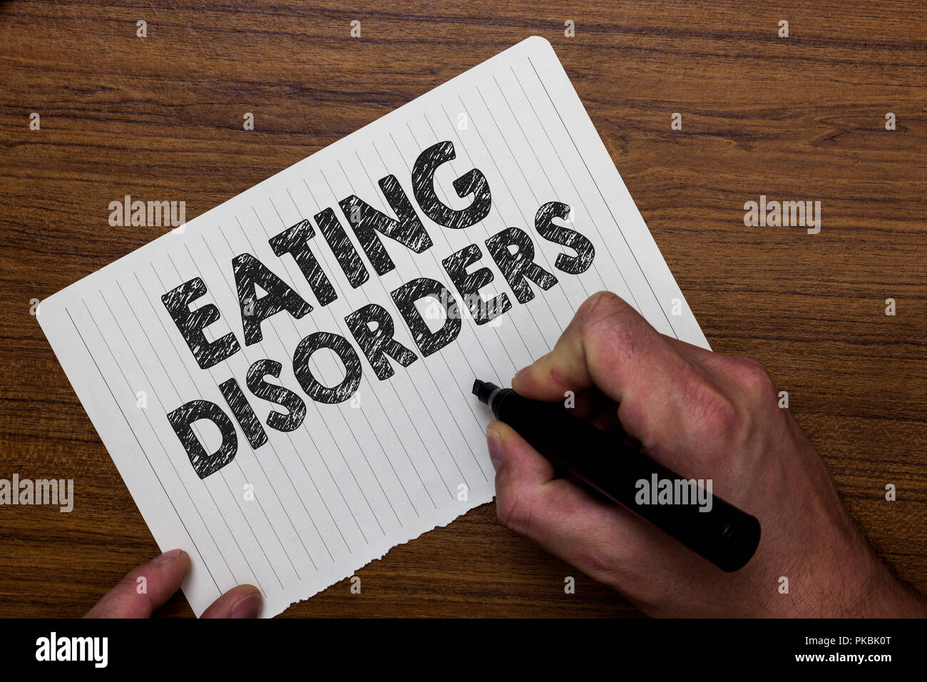 Writing note showing  Eating Disorders. Business photo showcasing any of a range of psychological abnormal food habits Man holding marker notebook pap Stock Photo
