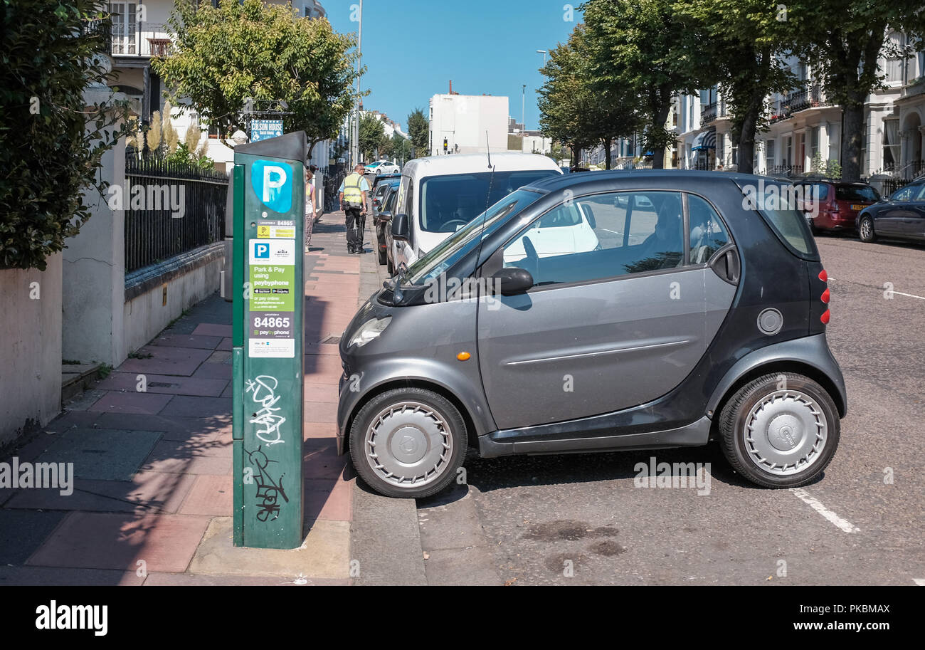 Smart car parked sideways in small space on street in Brighton UK Stock Photo