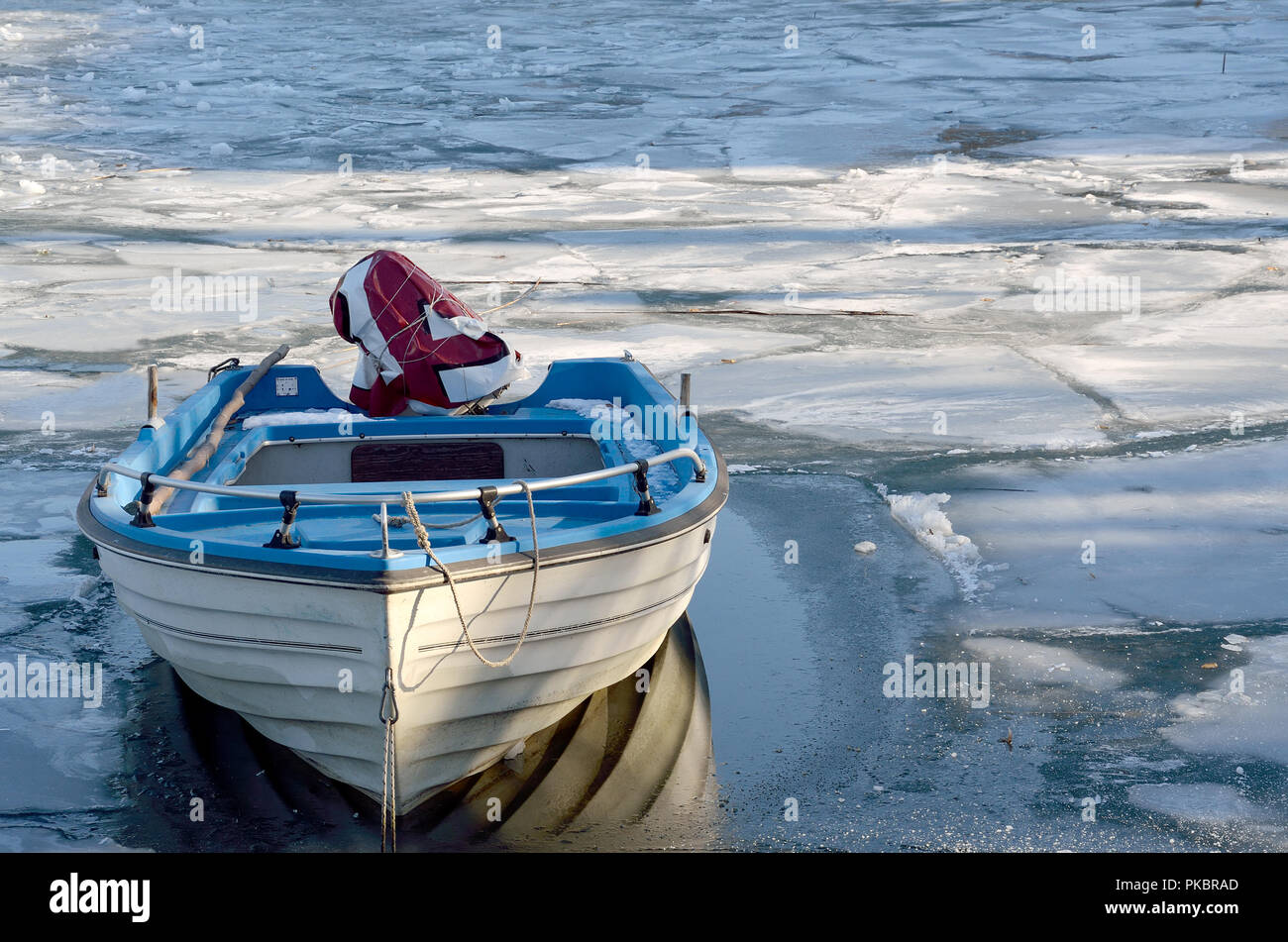 Boat in icy surface of lake Stock Photo