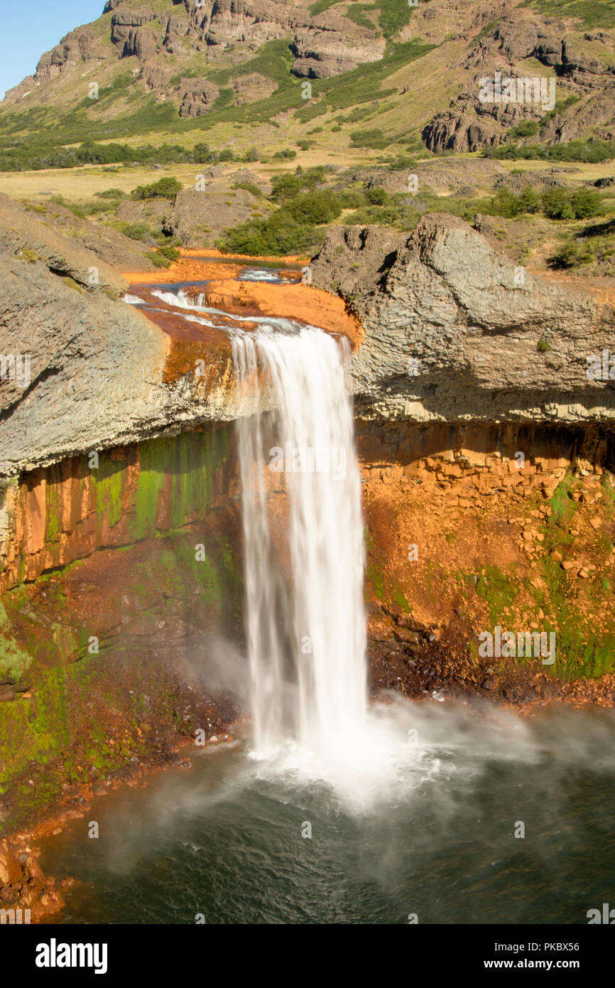 Waterfall cascades down a colourful volcanic canyon; Copahue, Neuquen, Argentina Stock Photo