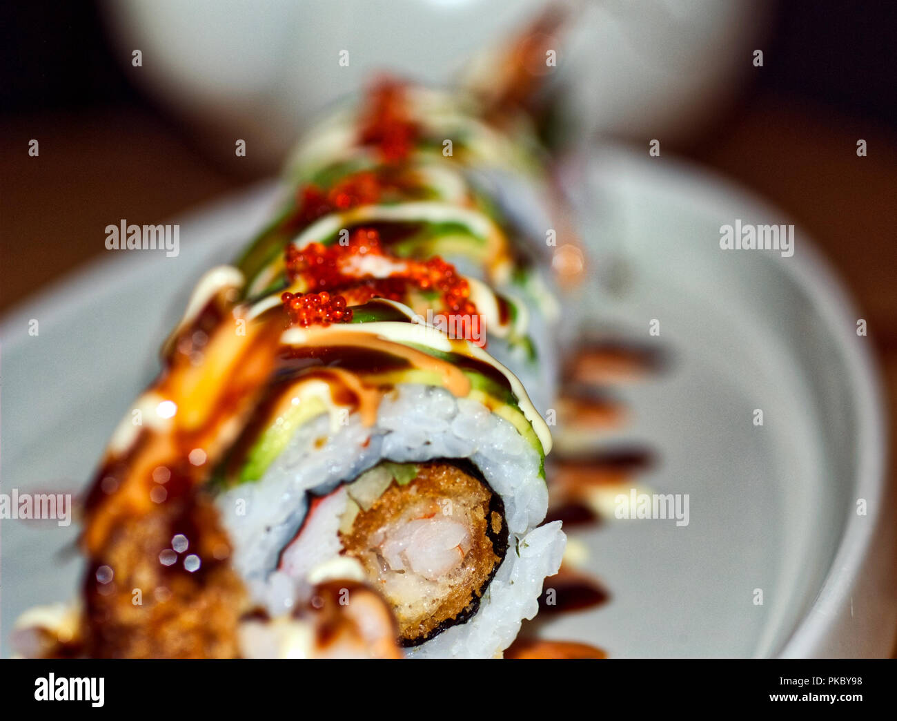 Delicious sushi roll, plated nicely with extravagant sauces. Stock Photo