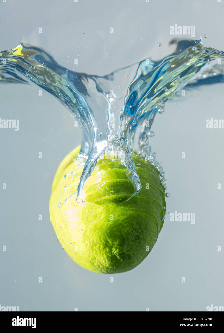 Fresh lime falling into the water. Suitable for advertisement. Stock Photo