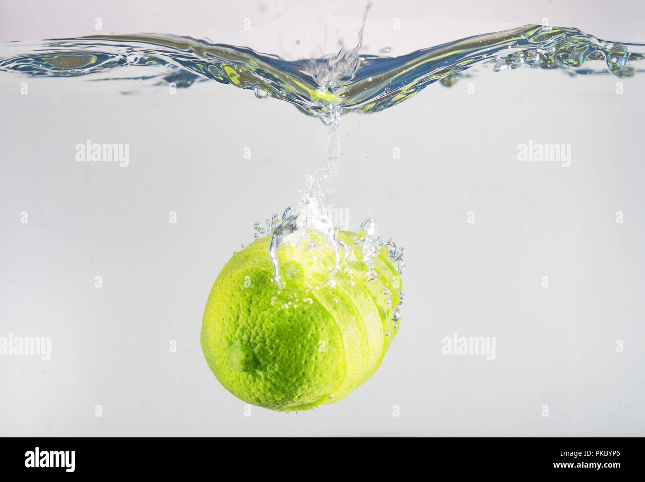 Fresh lime falling into the water. Suitable for advertisement. Stock Photo