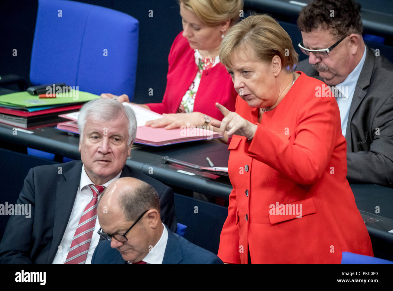 Berlin, Germany. 12th Sep, 2018. Federal Chancellor Angela Merkel (CDU) talks to Horst Seehofer (CSU), Federal Minister of the Interior, Home and Construction, during the general debate in the German Bundestag, while Olaf Scholz (SPD, front), Federal Minister of Finance and Hans-Joachim Fuchtel (CDU, r), State Secretary in the Ministry of Agriculture and Franziska Giffey (SPD, back left), Federal Family Minister sit on the government bench. Credit: dpa picture alliance/Alamy Live News Stock Photo