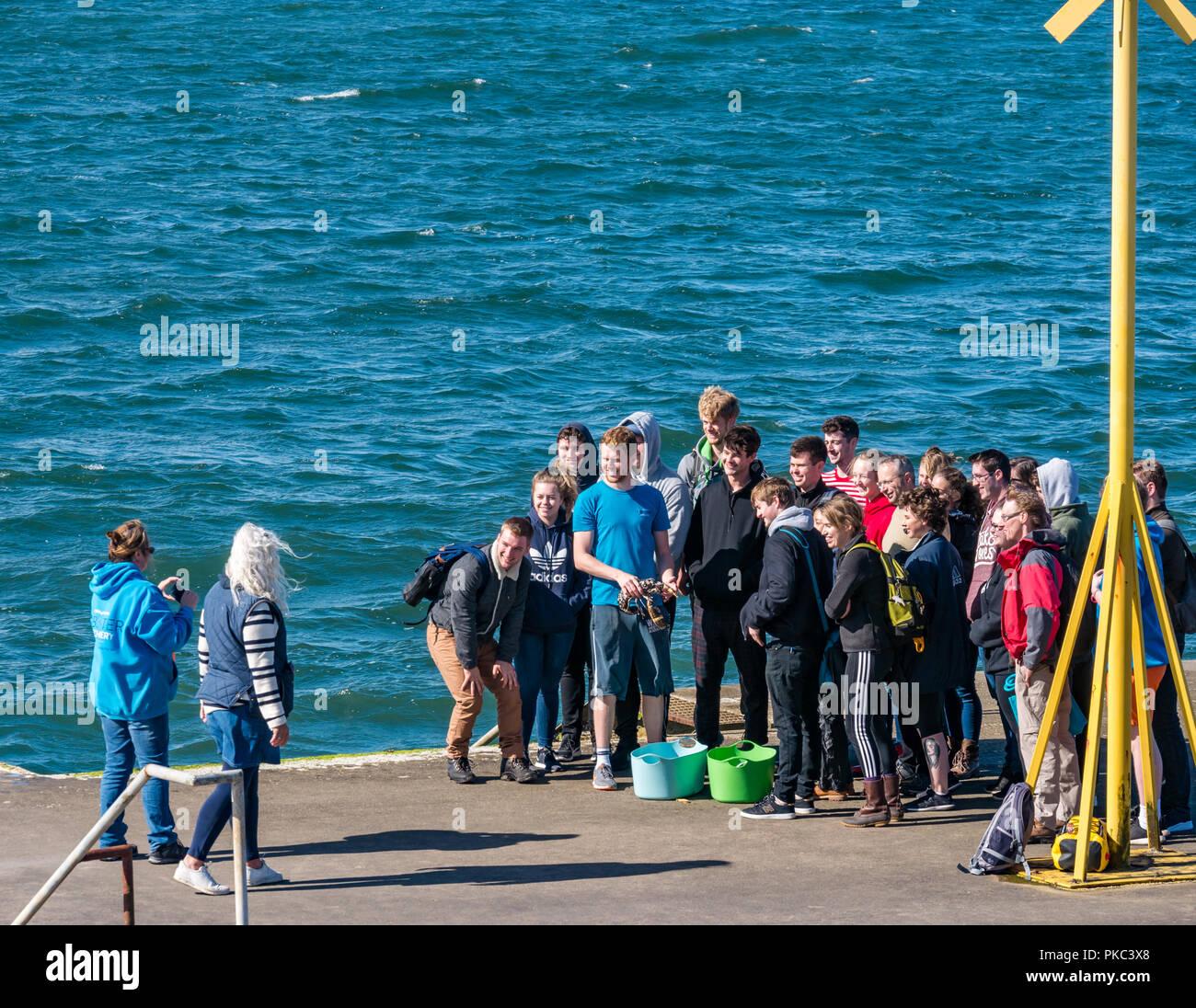 North Berwick, East Lothian, Scotland, UK, 12th September 2018. UK Weather: A beautiful sunny day on the Eastern Scottish coastline in the Firth of Forth. Students from Stirling University visit the North Berwick harbour lobster hatchery and release a lobster into the Firth of Forth from the jetty Stock Photo