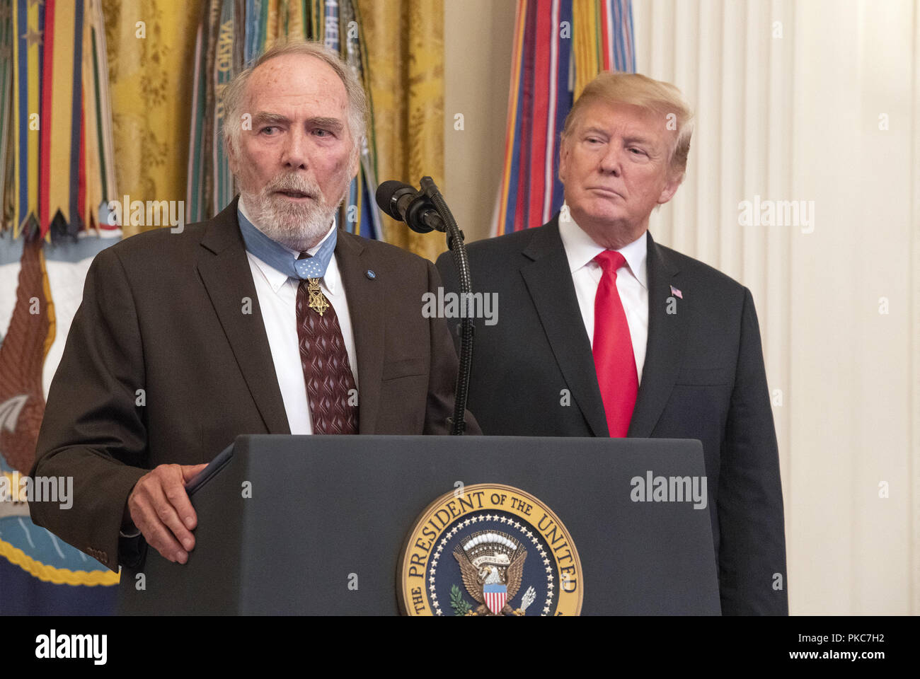 Washington, District of Columbia, USA. 12th Sep, 2018. United States Army Major Drew Dix (retired) a Congressional Medal of Honor recipient for heroism in the Vietnam War makes remarks at the Congressional Medal of Honor Society Reception as US President Donald J. Trump looks on from the right in the East Room of the White House in Washington, DC on Wednesday, September 12, 2018. Dix also serves as president of the Congressional Medal of Honor Society Credit: Ron Sachs/CNP/ZUMA Wire/Alamy Live News Stock Photo