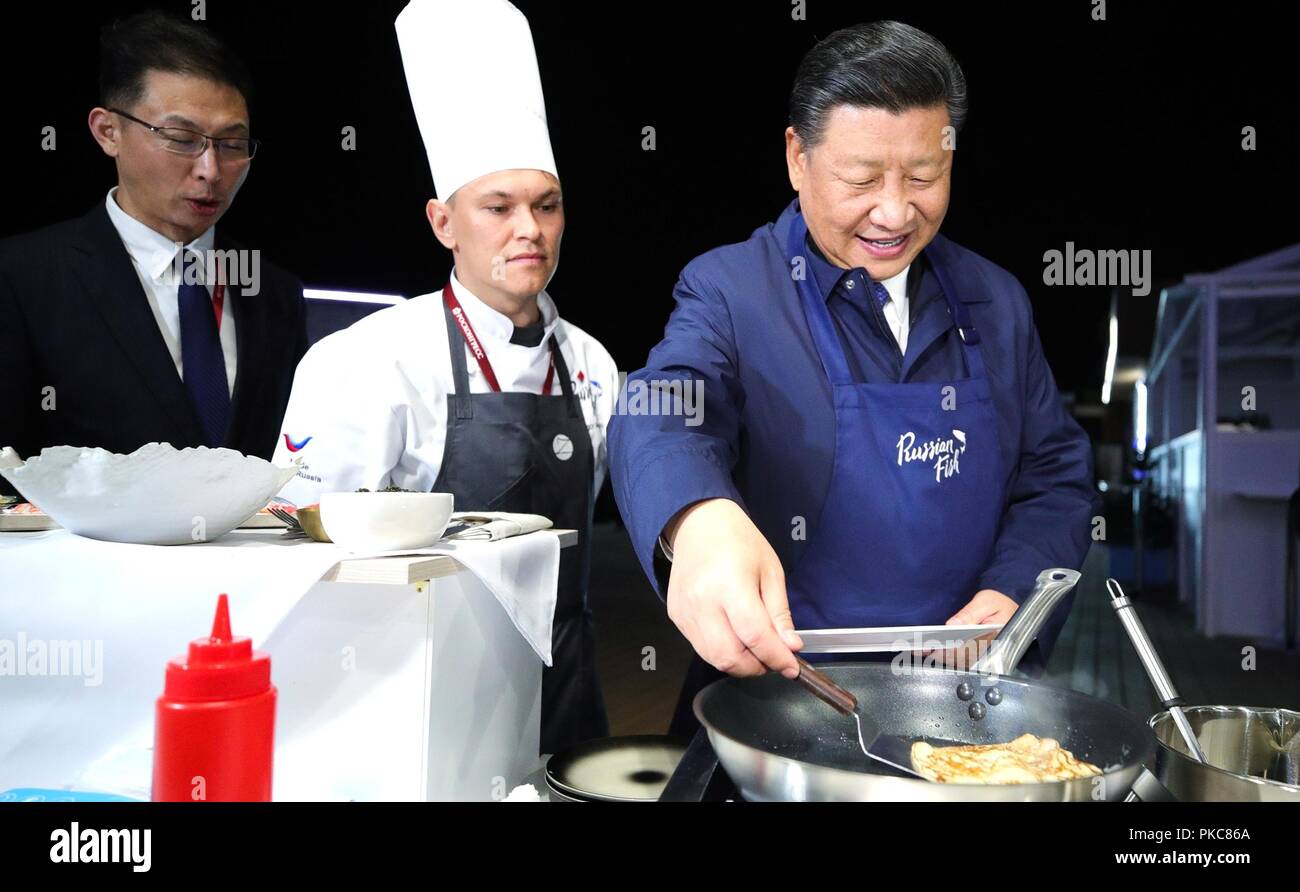 Chinese President Xi Jinping smiles as he cooks a Russian style blini ...