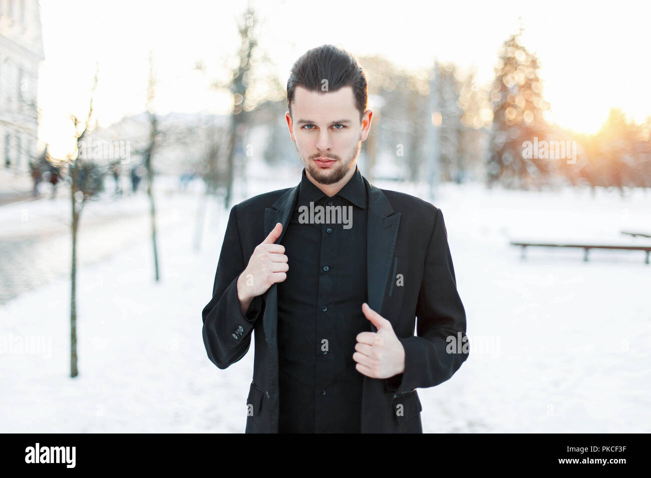 Handsome young man in a black suit at sunset Stock Photo