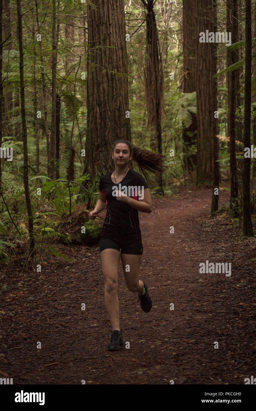 Young woman running in the forest Stock Photo