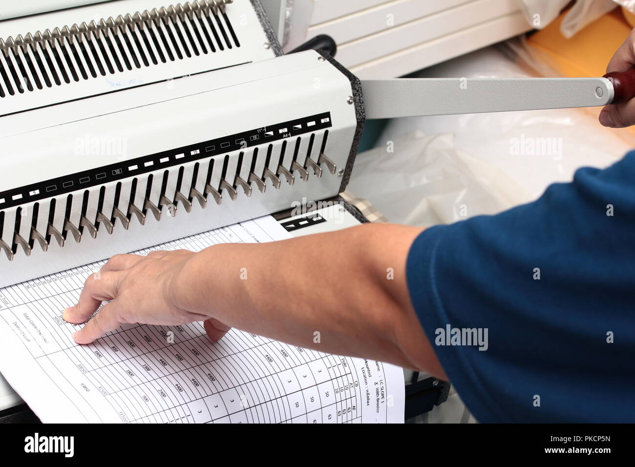 Binding documents ,Use your left hand to push the paper into the drill and used his right hand