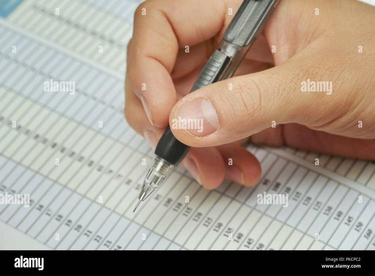 Right hand pencil extrusion preparation work on the paper that is a piece of work. Stock Photo
