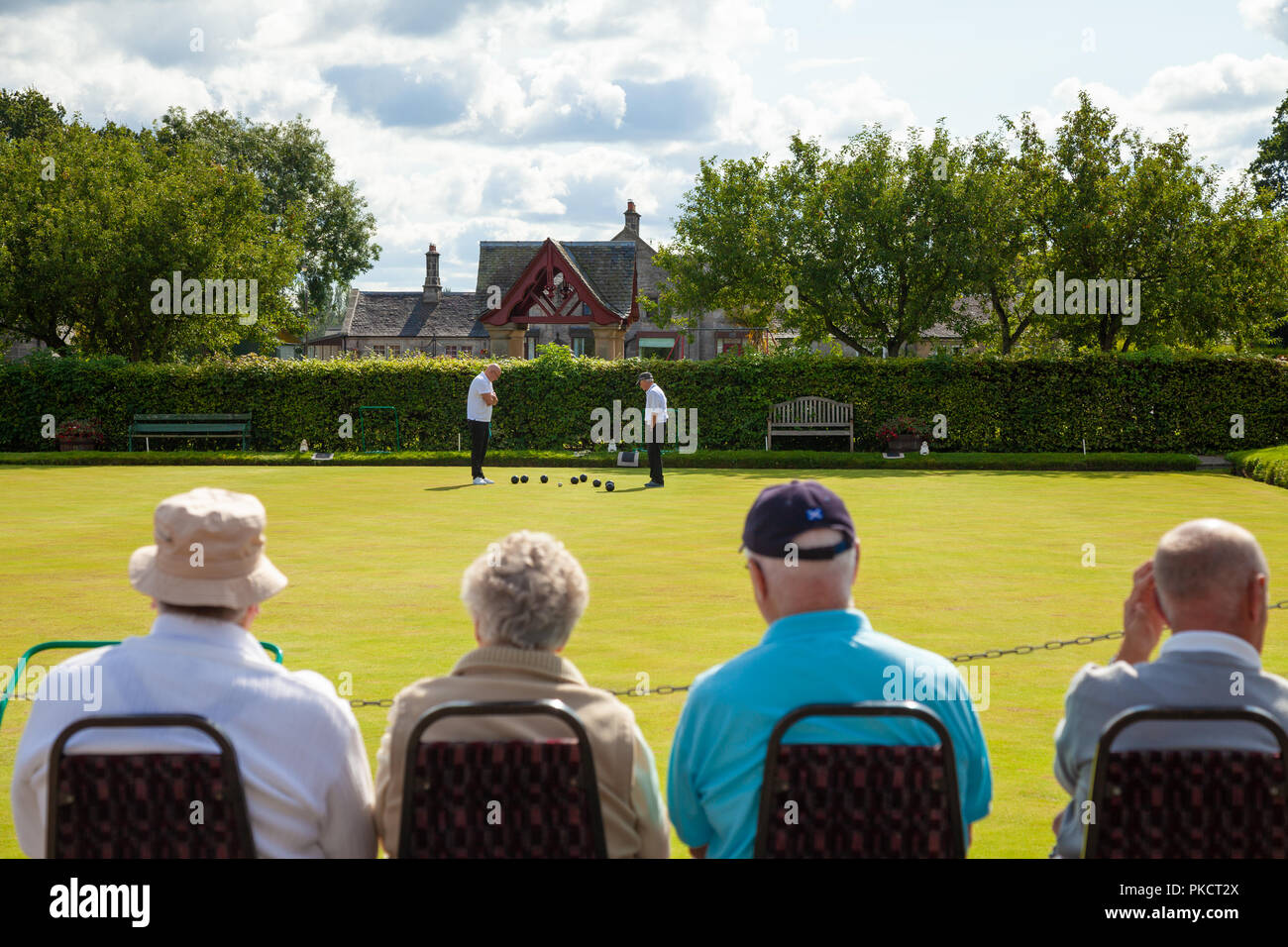 People watching a game of crown green bowls in Dunmore Village Scotland. Stock Photo