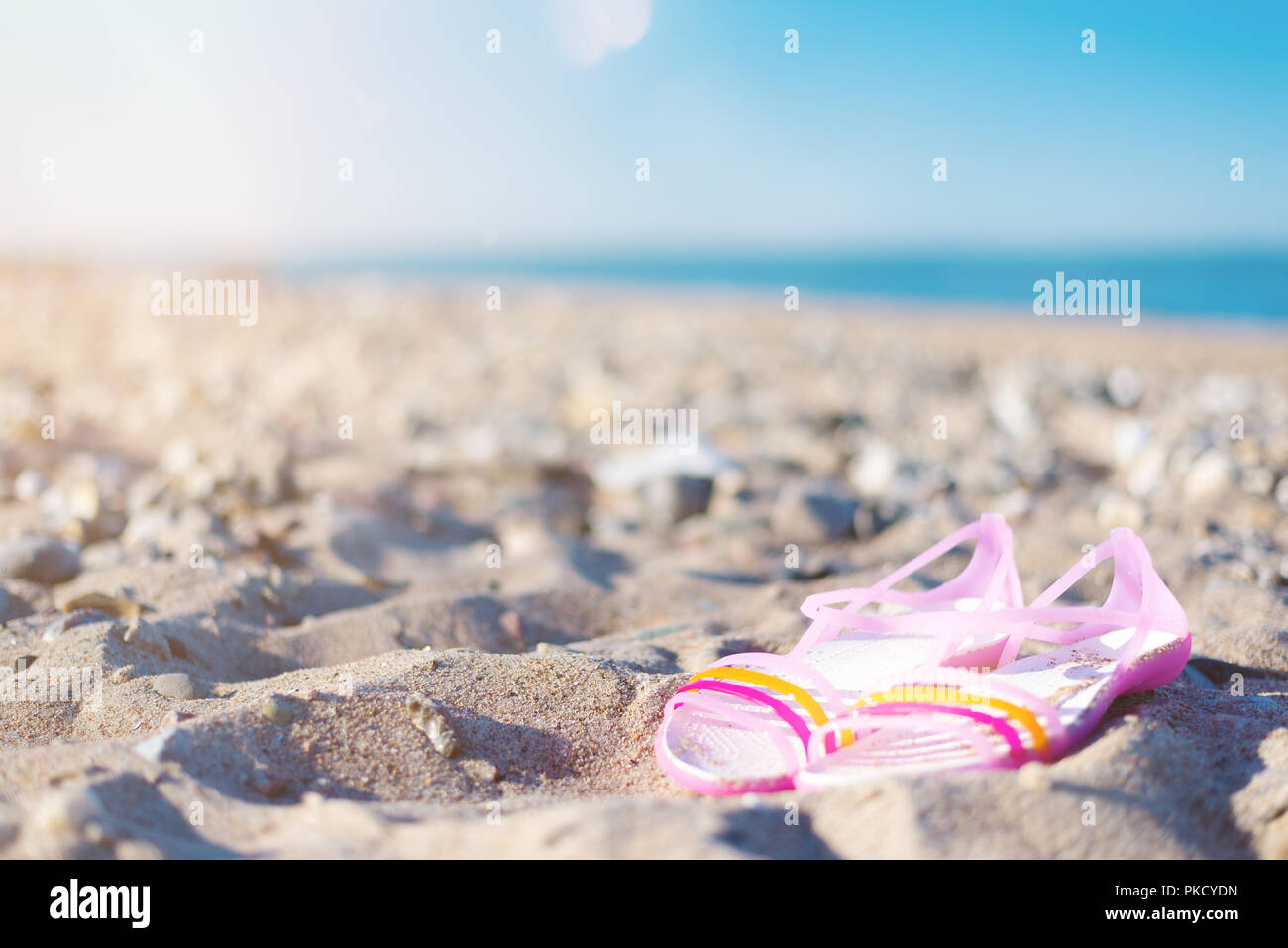 close-up of pair of sandals on empty beach on clear sunny summer day Stock Photo