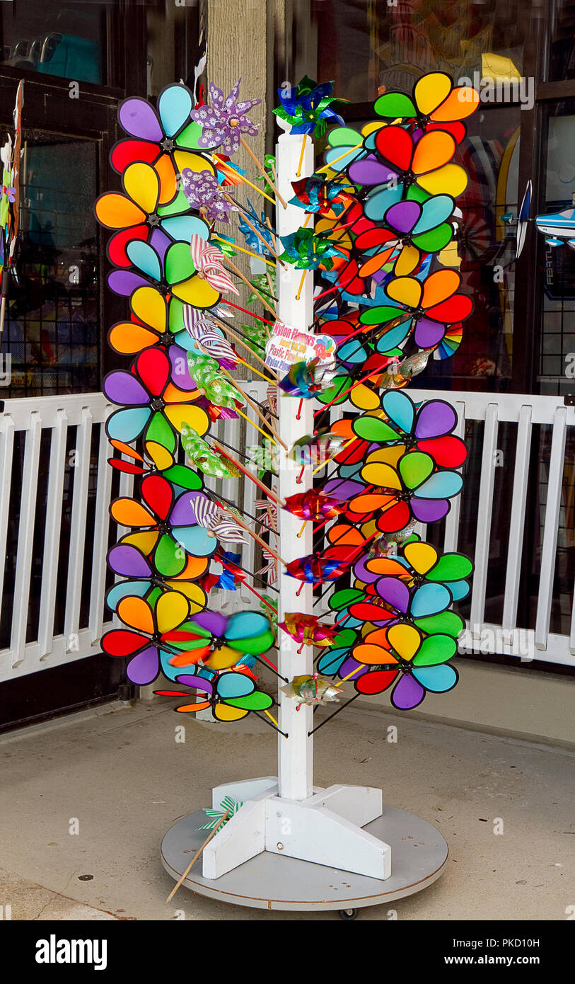 Novelty wind spinners in all different shapes and sizes on stands outside store off boardwalk. Stock Photo