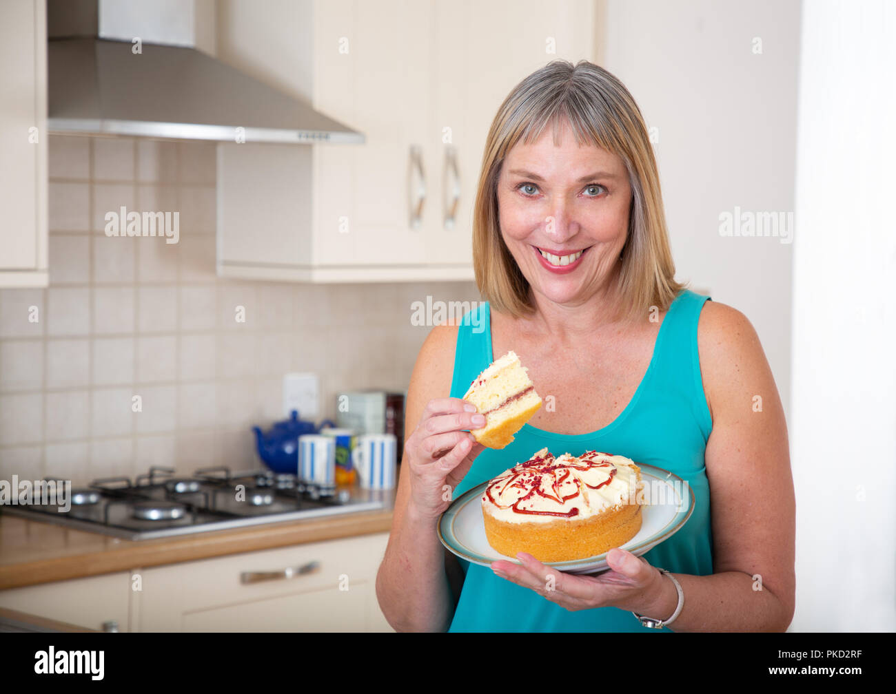 woman eating a cream sponge cake Stock Photo