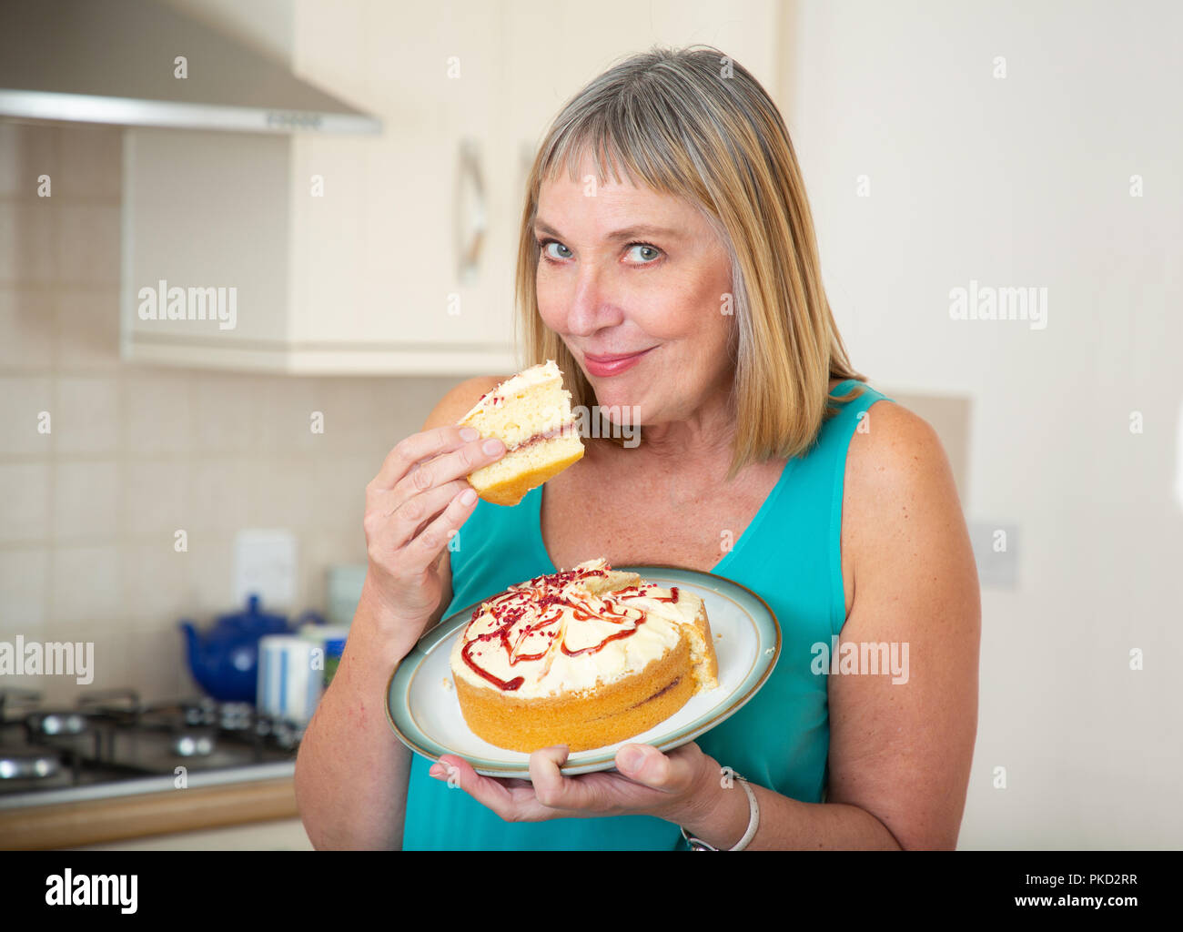 woman eating a cream sponge cake Stock Photo