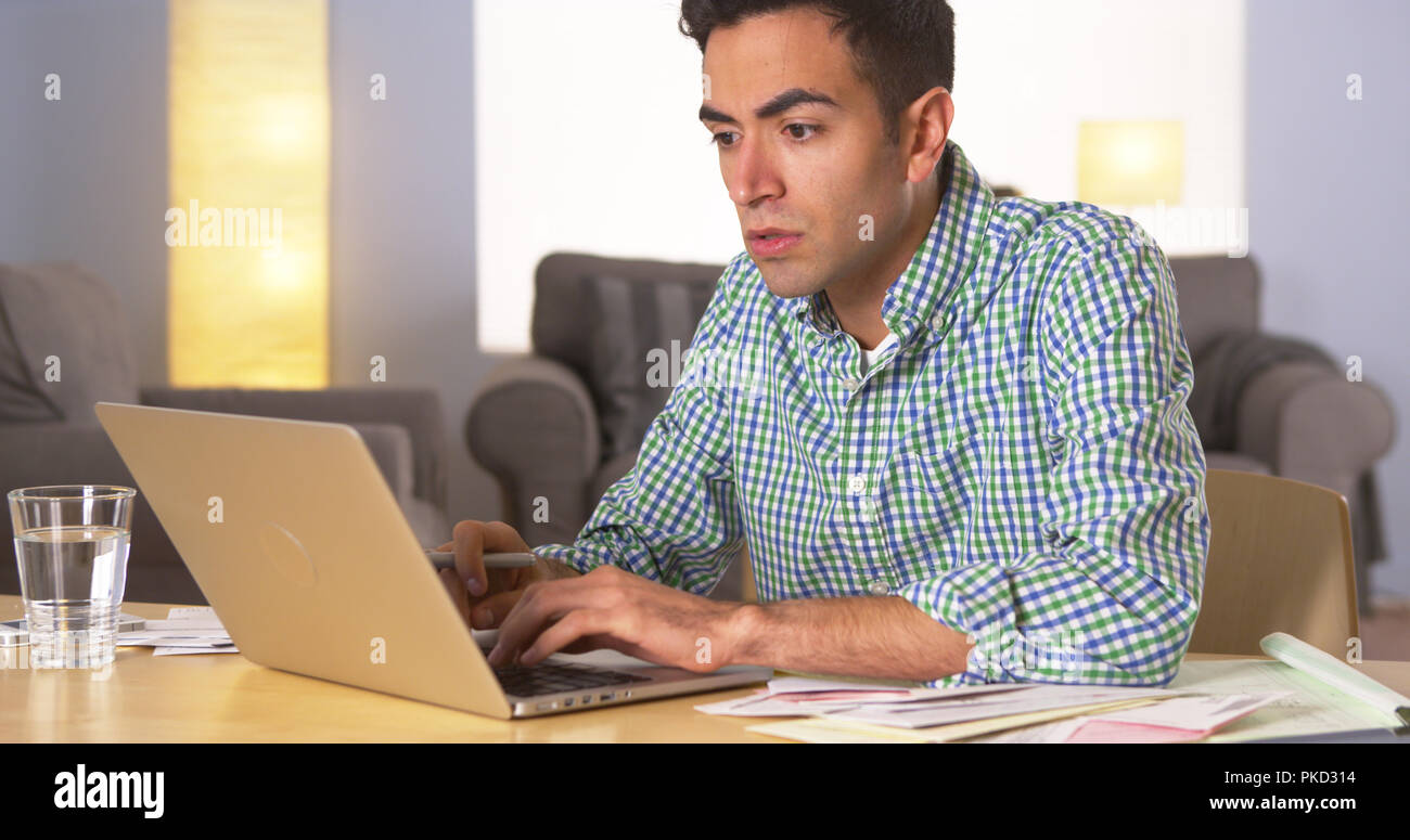 Mexican man paying bills at home Stock Photo