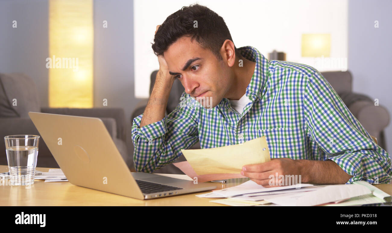 Mexican man feeling frustrated with bills Stock Photo