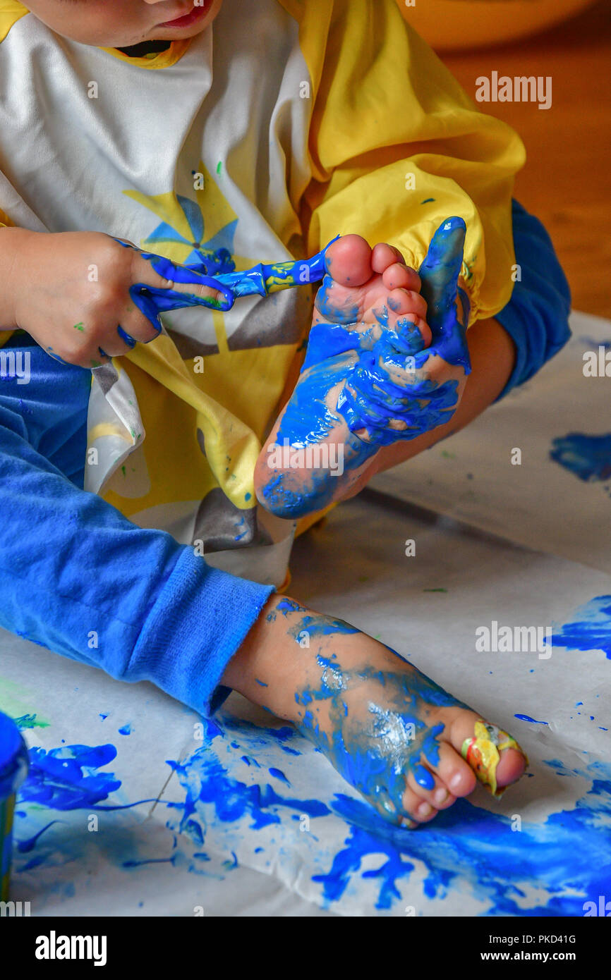 child painting it´s feet Stock Photo