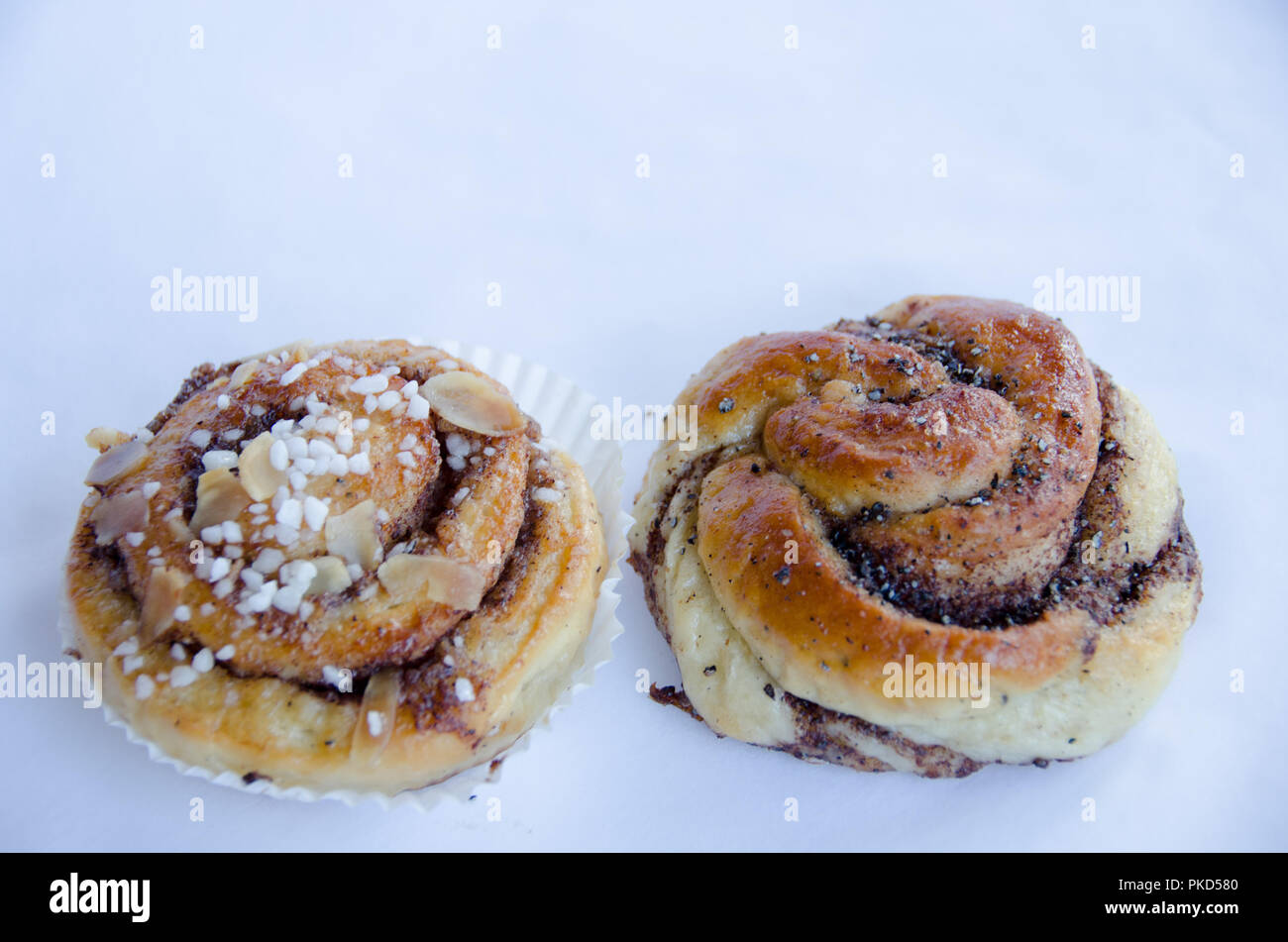 Cinnamon bun with a cardamon bun on white background Stock Photo