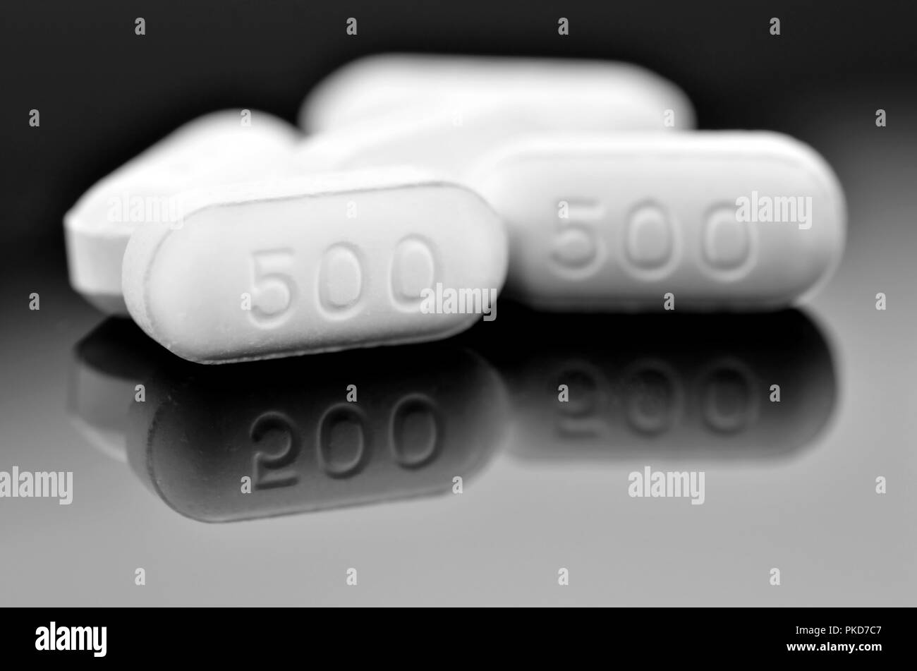 White caplet with reflection on dark background. Paracetamol 500 mg. tablet the OTC medicine for relif pain and fever. Stock Photo