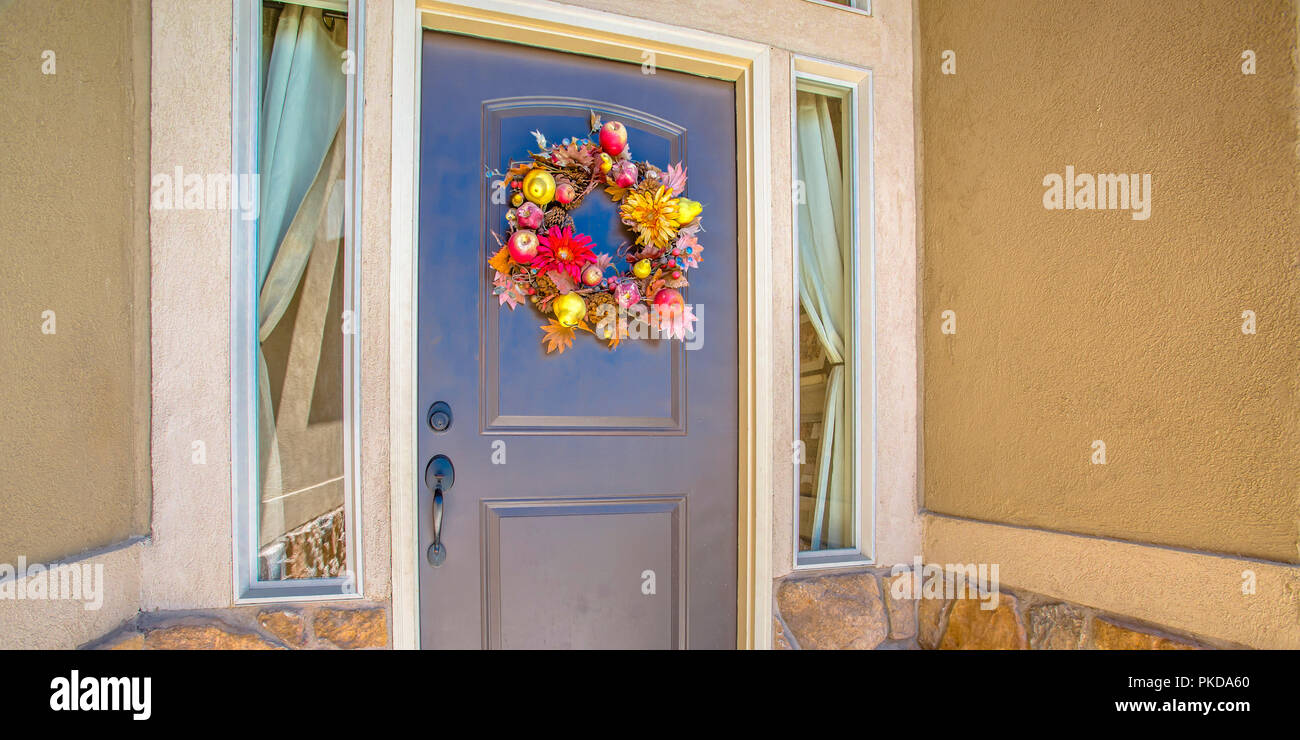 Blue front door with flower wreath between windows Stock Photo - Alamy
