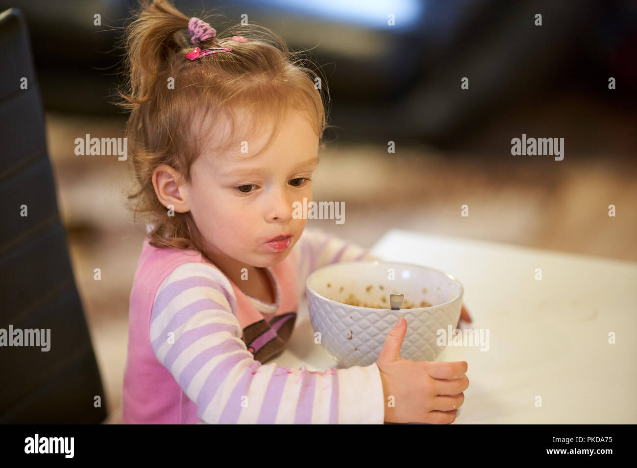 3 yearls old caucasian girl child is eating breakfast in the morning Stock Photo