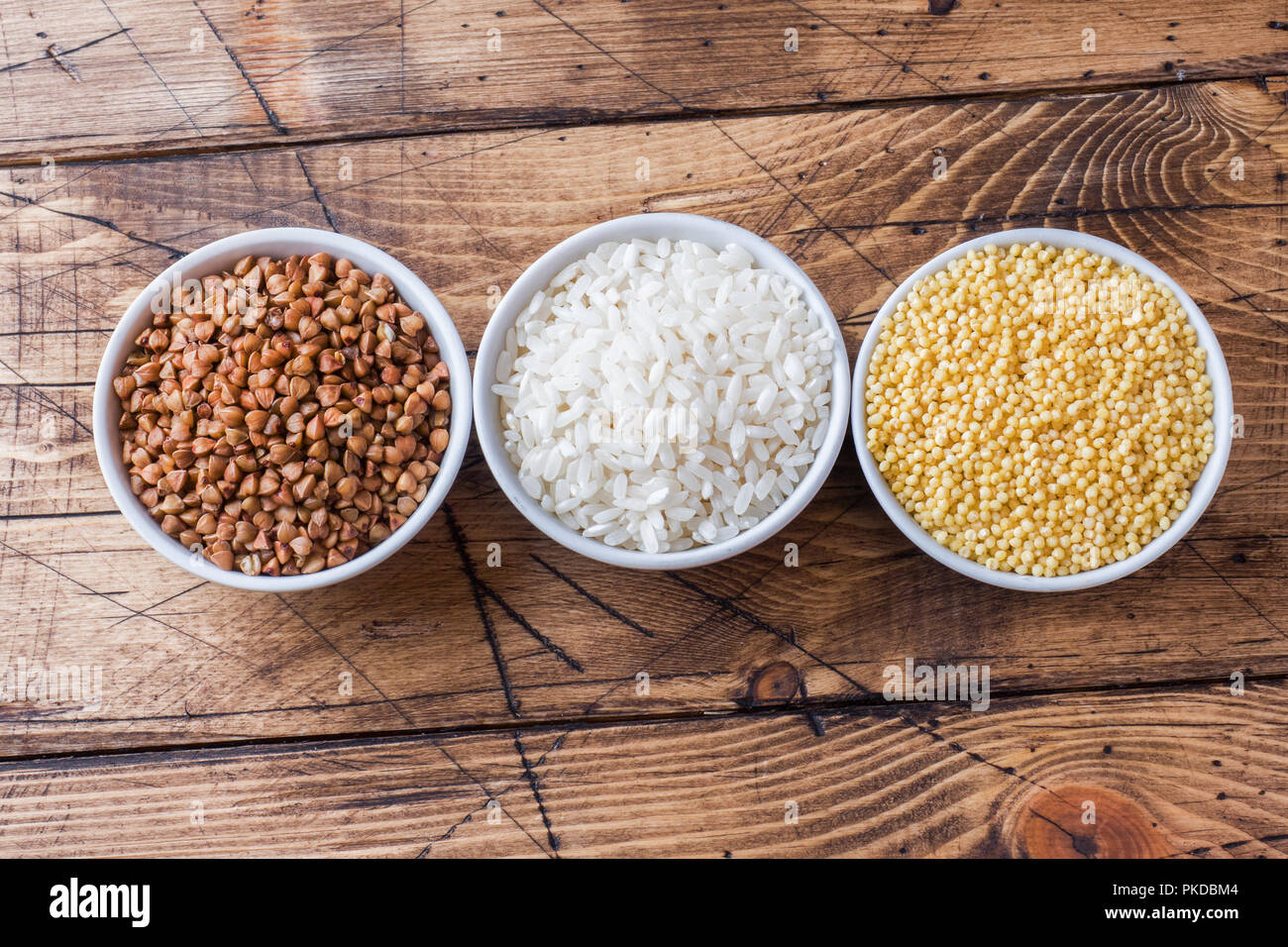 Dry groats grocery. Rice, buckwheat and millet on the wooden background