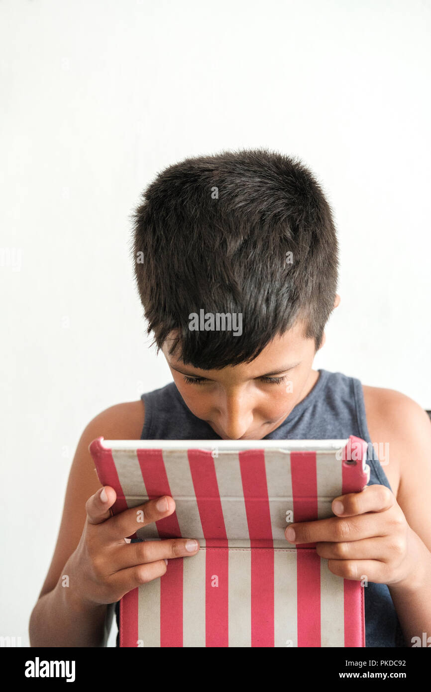 Bad eyesight-Child plays games ona tablet tablet Stock Photo